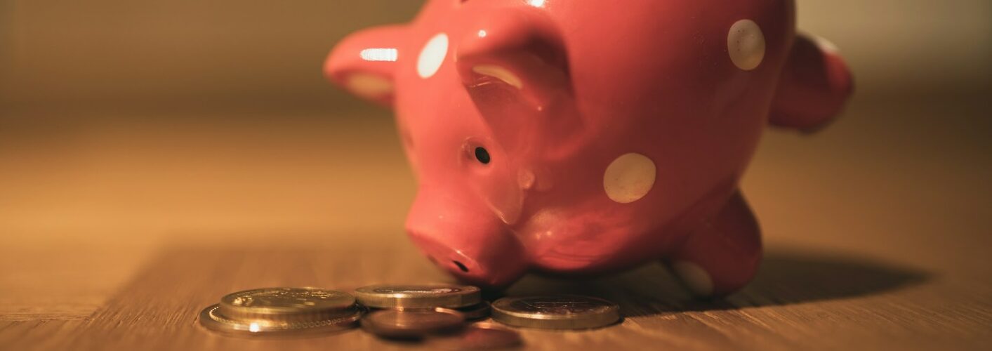 pink pig coin bank on brown wooden table