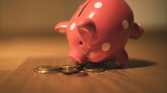 pink pig coin bank on brown wooden table